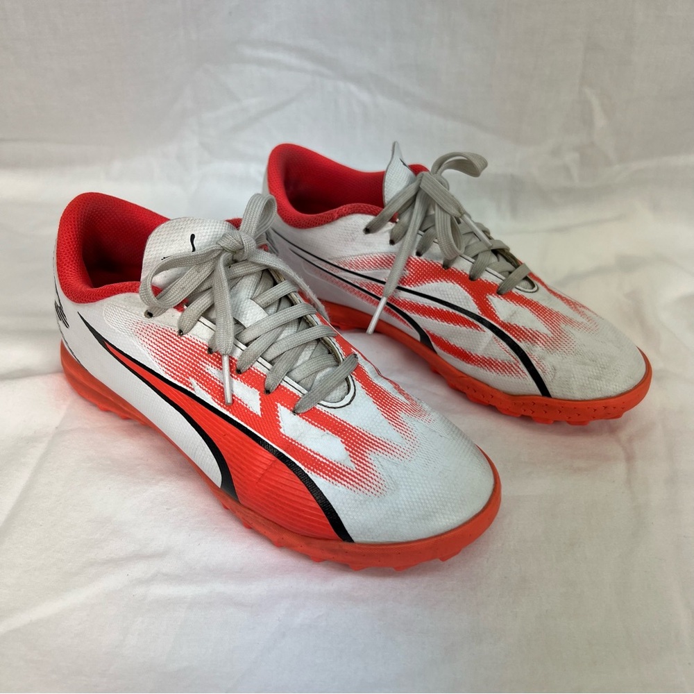 Puma kids turf shoes in white, bright coral and black.